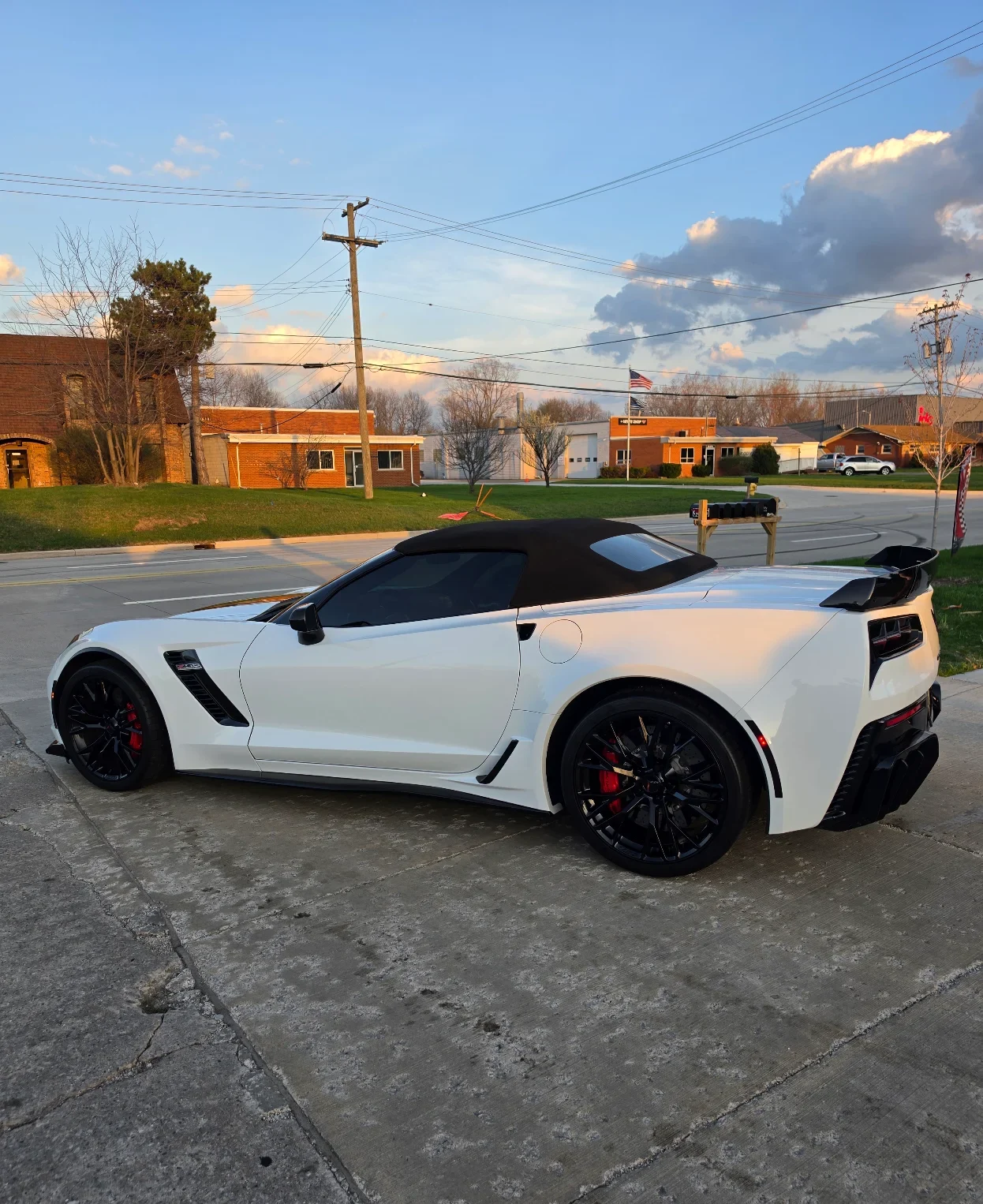 Side view of White C7 corvette with paint protection film installed on front half in Fraser, MI